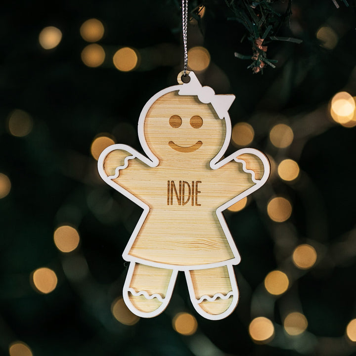 A personalized hanging ornament shaped like a gingerbread man with the name &