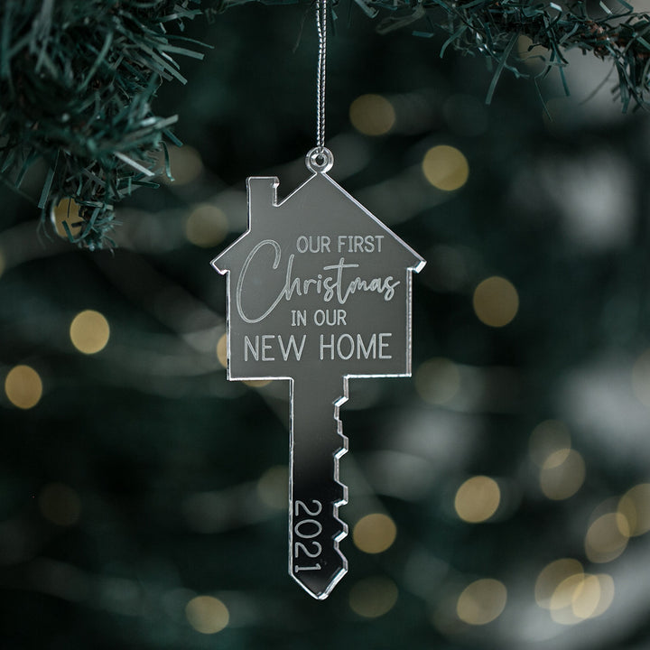 A customized Christmas ornament in the shape of a house key with the text &