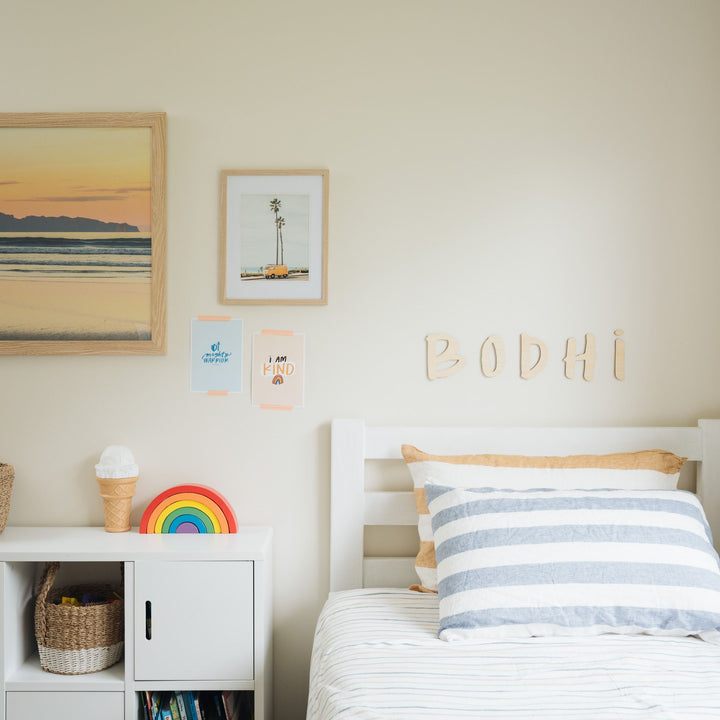 A bamboo hand lettered wall name saying Bodhi, hanging in a children&