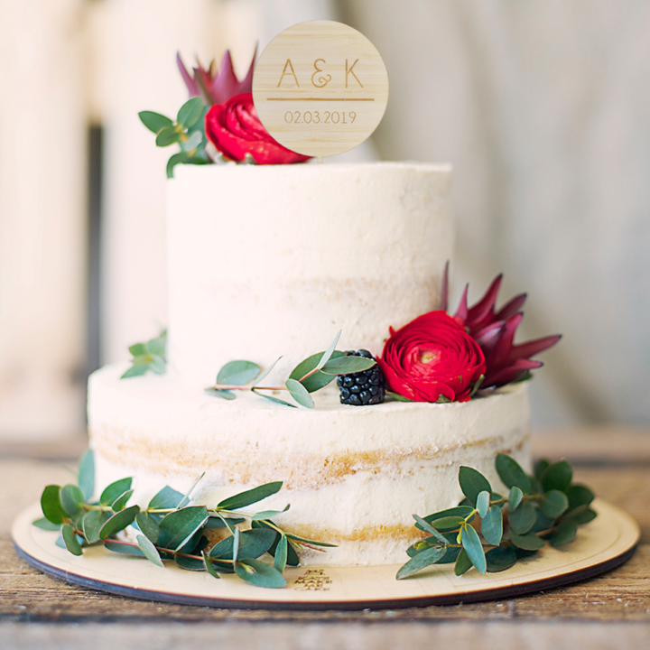 A simple two-tier semi-naked cake with eucalyptus, red flowers, and a blackberry, topped with the Together Cake Topper (two colours available), plus initials A & K and the date 02.03.2019.