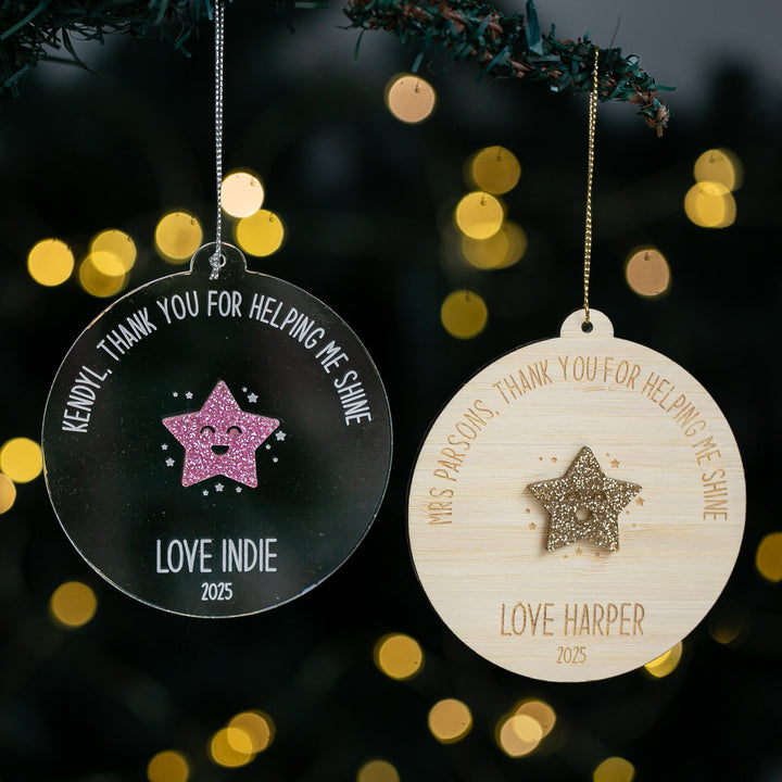 Two personalized Christmas ornaments with star designs and engraved text against a blurred light background.