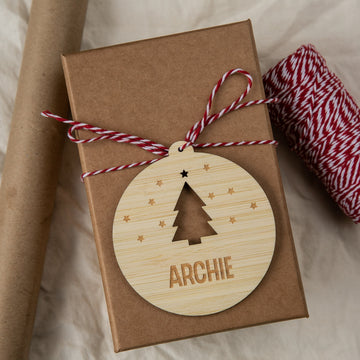 Gift box with a wooden ornament featuring a Christmas tree and the name &