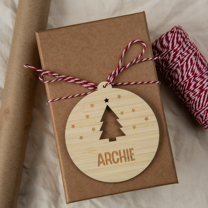 Gift box with a wooden ornament featuring a Christmas tree and the name &