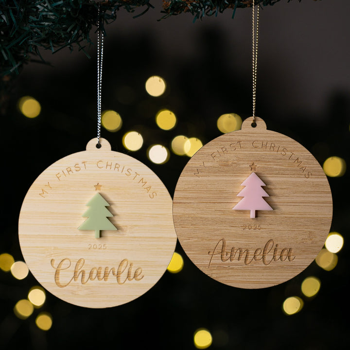 Two wooden Christmas ornaments with tree and star designs, personalized with names and years, against a festive background.