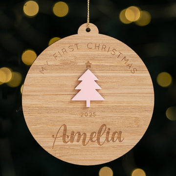 Wooden Christmas ornament with tree design and text on a blurred lights background