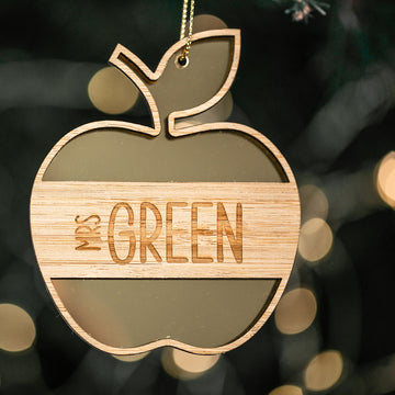 The Apple for the Teacher Christmas Bauble features an engraved apple-shaped design with "Mrs GREEN," hanging from a string. This personalised gift is ideal for teacher appreciation and adds festive charm to any holiday décor.