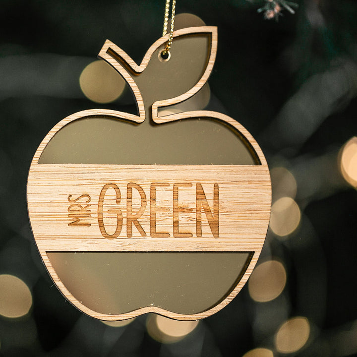 The Apple for the Teacher Christmas Bauble features an engraved apple-shaped design with "Mrs GREEN," hanging from a string. This personalised gift is ideal for teacher appreciation and adds festive charm to any holiday décor.