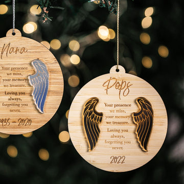 The Guardian Angel Memory Christmas Bauble, engraved with names and years like Nana and Pops, features angel wings and softly glows on the tree—an elegant ornament for cherishing loved ones during the holidays.