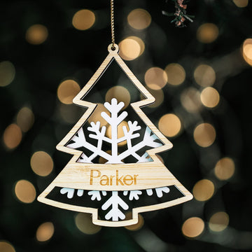A personalized Frosted Forest Christmas Bauble with a white acrylic snowflake base and a bamboo Christmas tree cut out with the name &