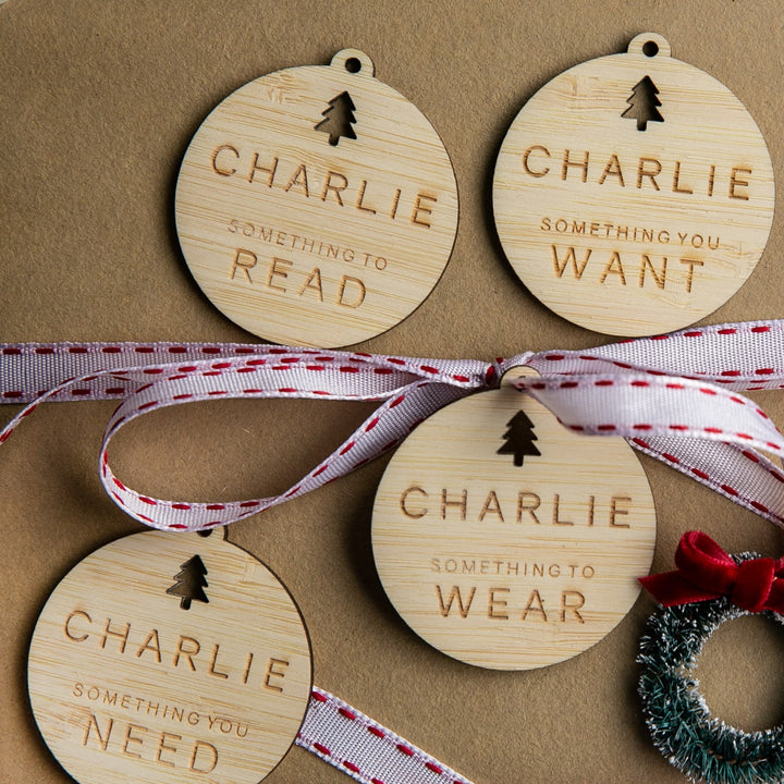 The Personalised Tree - Want, Need, Wear, Read Tags are four round wooden gift tags with a tree cutout, labelled for curated gifting.