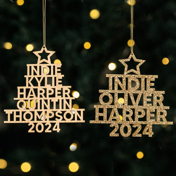 Two Whānau Christmas Tree Baubles (one wood, one gold glitter) personalised with names like Indie, Harper, and Thompson and “2024” cut out. Family ornaments shown with festive lights in the background.