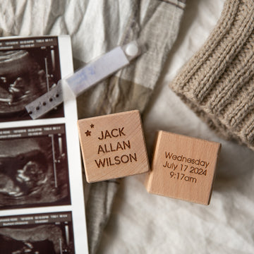 Personalised Wooden Blocks displayed on a blanket spell out JACK ALLAN WILSON and Wednesday July 17 2024 9:17am, alongside ultrasound images and a knitted hat—a charming engraved baby keepsake, ideal for a newborn gift announcement.