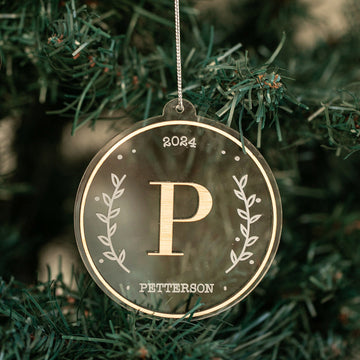 The Monogram Christmas Bauble is a round, clear ornament with gold trim, "2024," a large gold P, "Petterson," and leaf accents—making it the perfect personalised family keepsake for your Christmas tree.