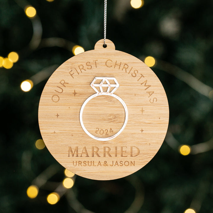 The Diamond Ring Christmas Bauble, crafted from eco-friendly bamboo and engraved with “OUR FIRST CHRISTMAS MARRIED 2024” and “URSULA & JASON,” makes a perfect personalised engagement ornament for your festive tree.