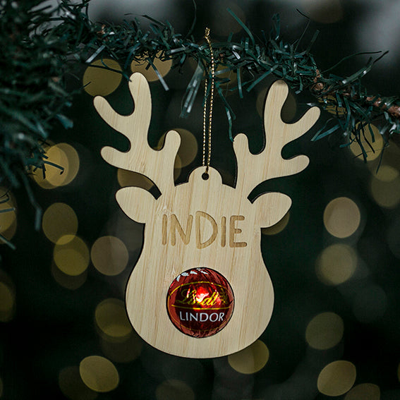 A Christmas ornament featuring a reindeer with a &