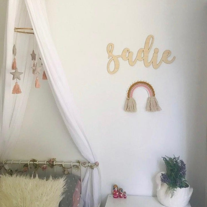 A bamboo wall name saying Sadie, hanging in a little girls room.
