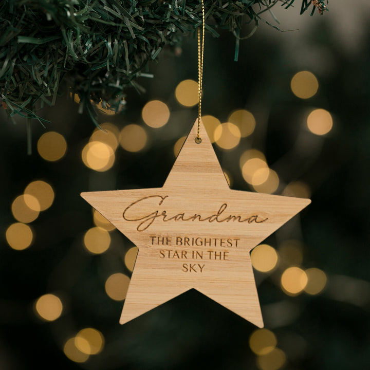 A wooden star-shaped Christmas ornament with the engraved text &