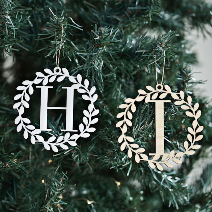 The Alpha Wreath Christmas Bauble set includes two wreath-shaped ornaments with leafy designs, each featuring a bold initial—H and I—for a charming, personalised touch to your Christmas tree.