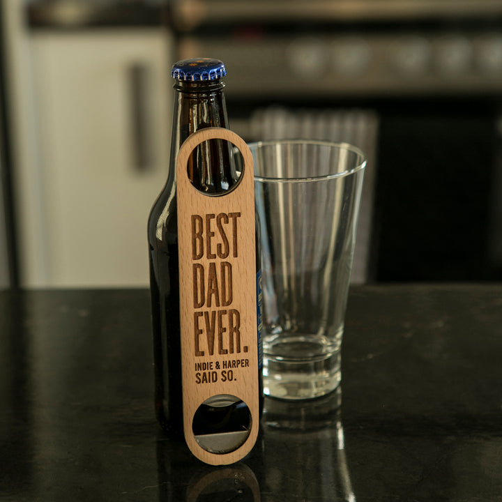 A Personalised Bottle Opener (3 designs available), engraved with BEST DAD EVER. INDIE & HARPER SAID SO., rests by a beer bottle and glass—a practical, thoughtful gift for men who appreciate personal touches.