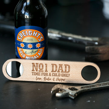 A Personalised Bottle Opener (3 designs available), engraved with NO 1 DAD TIME FOR A COLD ONE? Love, Stevie & Harper, sits by a Speights Gold Medal Ale and a wrench—a practical men’s gift for any occasion.