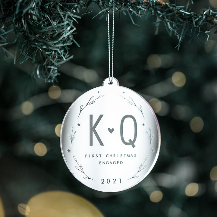 The Lovers Christmas Bauble is a white, round ornament for your tree, featuring K ♥ Q initials, "First Christmas Engaged," the year 2021, and simple branch designs—a unique keepsake or wedding gift.
