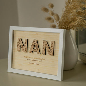 A thoughtful gift for grandmothers, the Wildflower Frame Insert (frame not included) displays “NAN” in floral letters beside a vase of dried grasses, with your personalised message engraved below for a heartfelt touch.