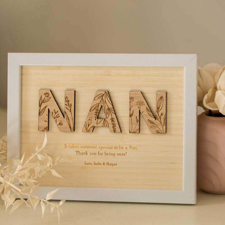 A Wildflower Frame Insert (frame not included) features large NAN letters with floral patterns and engraved text: "It takes someone special to be a Nan." Dried flowers nearby. A thoughtful gift from Love, Indie & Harper.