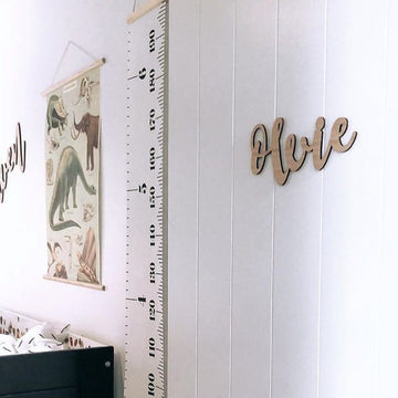 A bamboo wall name saying Olvie, hanging on the door of a child&