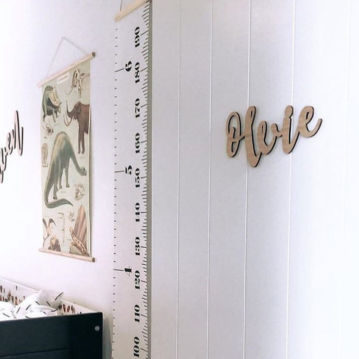 A bamboo wall name saying Olvie, hanging on the door of a child&