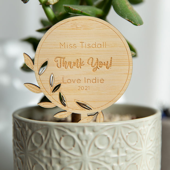The Personalised Stem Teacher Planters feature an eco-friendly bamboo marker engraved with “Miss Tisdall Thank You! Love Indie 2021," leaf carvings, and a succulent—making it a thoughtful teacher gift.