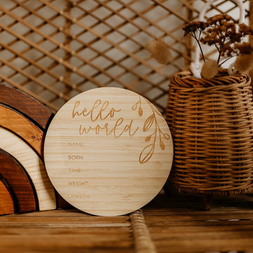 The Round Birth Announcement Card is a round, eco-friendly bamboo plaque engraved with hello world, with spaces for name, birth date, time, weight, and length.