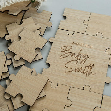 The Personalised Guestbook Jigsaw Puzzle features light wood pieces and a completed section engraved “Wishes for Baby Smith,” creating a unique, custom event keepsake.