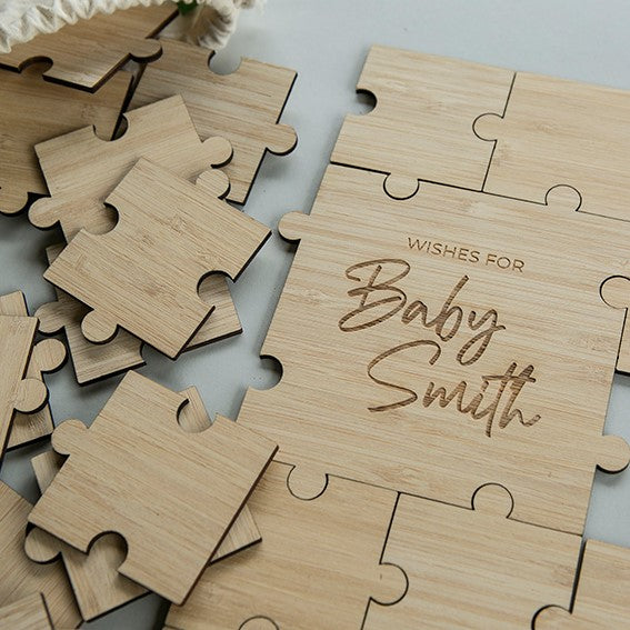 The Personalised Guestbook Jigsaw Puzzle features light wood pieces and a completed section engraved “Wishes for Baby Smith,” creating a unique, custom event keepsake.