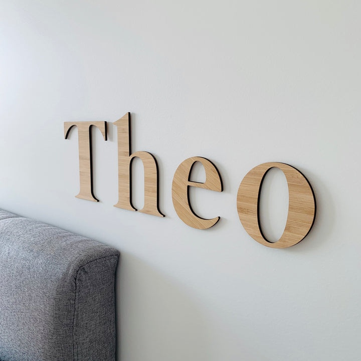 Bamboo classic wall lettering saying Theo. Hanging on the wall of a child&