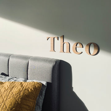 Bamboo classic wall lettering saying Theo. Hanging on the wall of a child&