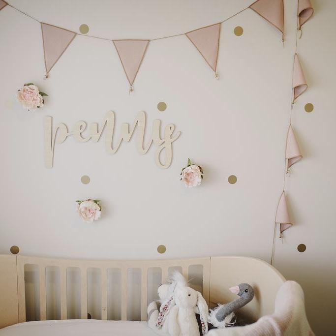 A bamboo wall name saying Penny, hanging in a little girls room.