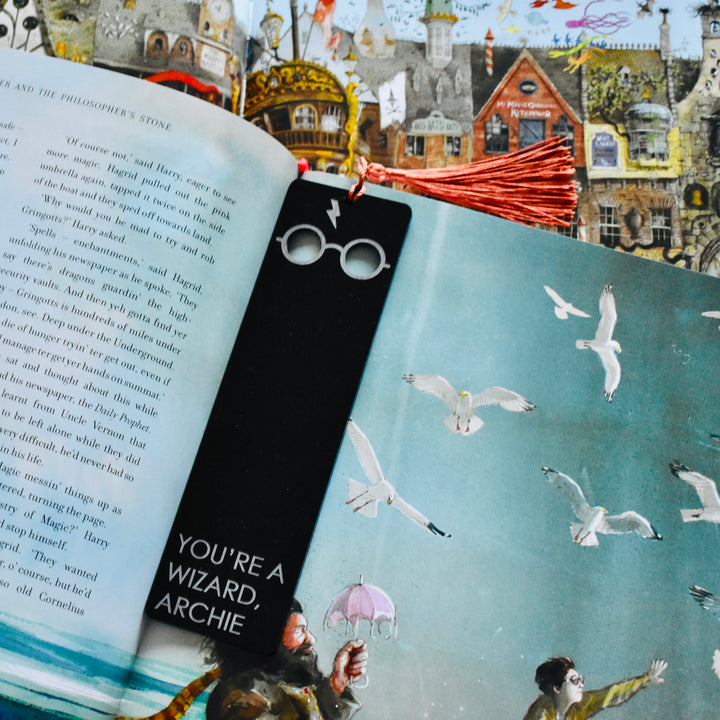 A black acrylic bookmark with Harry Potter glasses and scar etched at the end, with the words You&