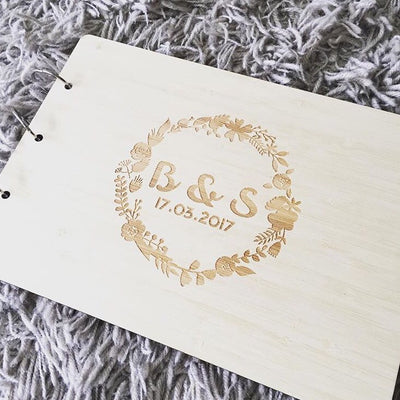Light bamboo sample wedding guestbook, bound with jump rings and engraved with custom floral wreath design on the cover
